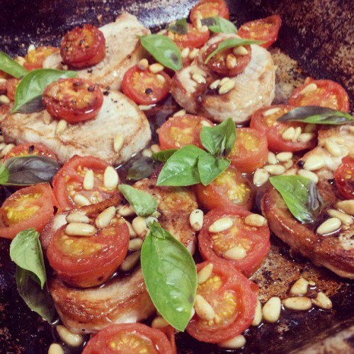Roast pork steaks with tomatoes and pine nuts